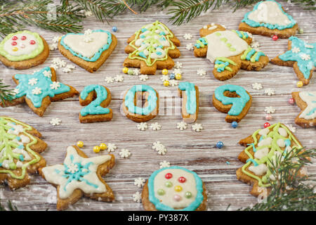 Glasierte Weihnachten Lebkuchen und Weihnachtsbaum Niederlassungen auf einer hölzernen Hintergrund Stockfoto