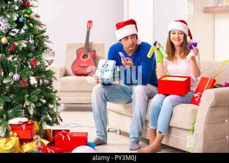 Junges Paar Weihnachten zu Hause feiern. Stockfoto