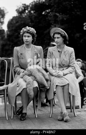 Prinzessin Elizabeth mit rund 19 Jahre alt und ihre Schwester, Prinzessin Margaret, 15 Jahre alt, im Jahr 1945, als ihre Mutter, die Königin, präsentiert service Spangen an Mitglieder der Women's Land Army im Windsor Great Park Foto von Tony Henshaw Stockfoto