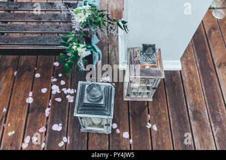 Hochzeit Dekorationen, Laternen, Bänke, Blumen und Rosenblätter verstreut auf dem Boden Stockfoto