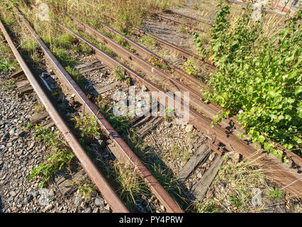 Alten rostigen Schienen in verlassenen Bahnhof. Rusty zug Eisenbahn detail, Granit Steine zwischen den Schienen Stockfoto