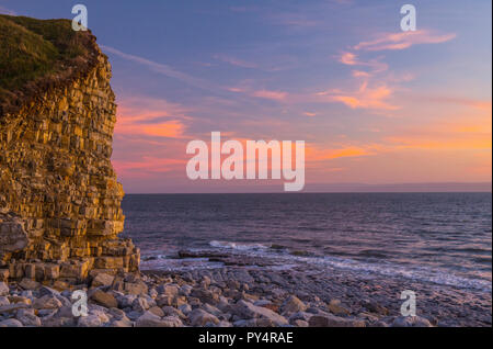 Ein rosa Himmel über llantwit Major Strand nach einem starken Sonnenuntergang, an der Glamorgan Heritage Coast, South Wales Stockfoto