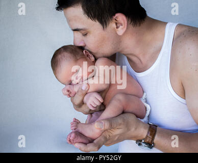 Vater holding New Born Baby schließen Küssen mit dem Kopf. Stockfoto