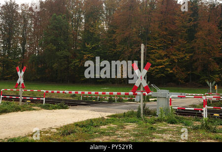 Bahnübergang mit geschlossenen roten und weißen Barriere und St. Andrews schneidet bei Schotterstraße in der Landschaft Stockfoto