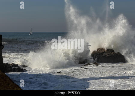 Welle brechen gegen die Felsen in der Nähe der Hafeneinfahrt des Douro River Mouth, Porto, Portugal Stockfoto