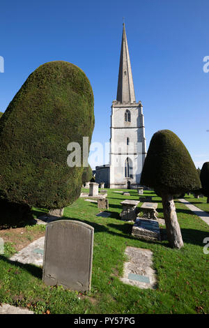 Painswick St Mary's Pfarrkirche mit Eiben auf dem Friedhof am Nachmittag, Sonnenschein, Painswick, Cotswolds, Gloucestershire, England, Großbritannien Stockfoto