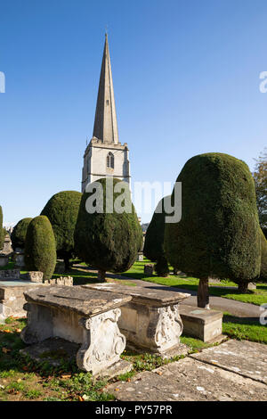 St Mary's Pfarrkirche mit Eiben und Brust Gräber auf dem Friedhof in Nachmittag Sonnenschein, Painswick, Cotswolds, Gloucestershire, England, Großbritannien Stockfoto