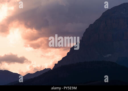 Sun Peaks von hinter den Wolken über Crowsnest Berg und Sieben Schwestern Berg Stockfoto