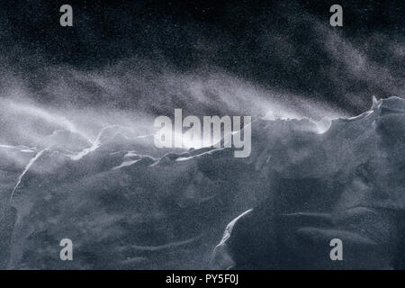 Wind weht frischer Schnee über einen Damm Stockfoto