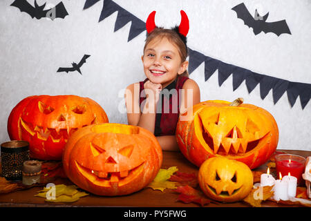 Happy Halloween. Lustige kleine Kind Mädchen mit dem Schnitzen Kürbis Süß. Glückliche Familie Vorbereitungen für Halloween. Stockfoto