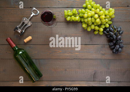 Glas Rotwein mit Flasche Wein und Trauben Stockfoto
