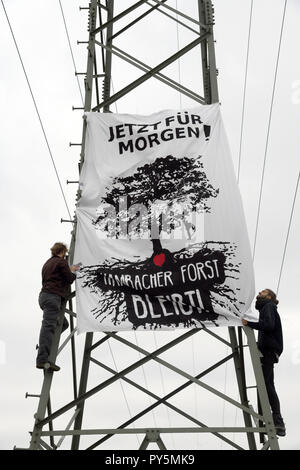 25 Oktober 2018, Nordrhein-Westfalen, Düren: Aktivisten hängen Sie ein Banner mit der Aufschrift "Jetzt für Morgen - Hambacher Forst bleibt!" auf eine Pipeline Pol in das neue Lager der Aktion Bündnis' Ende Gelände". Die demonstranten der Aktion Bündnis wollen neue Aktionen gegen Kohle Bergbau im Hambacher Forst vom Protest Camp zu starten und die Infrastruktur der Tagebau Block, wie Bagger, am Wochenende (27./28. Oktober 2018). Foto: Henning Kaiser/dpa Stockfoto