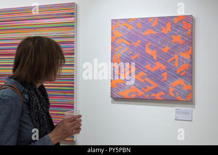 London, Großbritannien. 25. Oktober 2018. Der ein Besucher Synthese Orange Blau Gelb", 2016, von Colin McCallum. Vorschau von 'Metropole', eine Einzelausstellung von den letzten Gemälde des Künstlers Colin McCallum am Hebel Galerie. Die Ausstellung läuft vom 26. Oktober bis 10. November 2018. Credit: Stephen Chung/Alamy leben Nachrichten Stockfoto