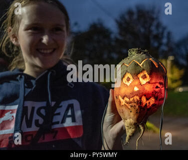 Hinton St George, Somerset, UK - 25. Oktober 2018. Eine junge Frau hält einen "Punkie" während der jährlichen punkie 'Nacht' Prozession um Hinton St George Dorf. Ein "Punkie' ist einer ausgehöhlten Mangold oder mangle-wrurzel leuchtet eine Kerze in einer Laterne zu machen. Obwohl die Ursprünge der benutzerdefinierten sind undurchsichtig Legende hat es, dass die ehefrauen der Hinton St George ging ihre Ehemänner zu getroffen als sie wieder aus dem Chiselbrough Messe kam, am letzten Donnerstag im Oktober statt. Sie Laternen aus Ausgehöhlten mangle-wurzels ihre Weise zu beleuchten. Credit: Tom Corban/Alamy leben Nachrichten Stockfoto