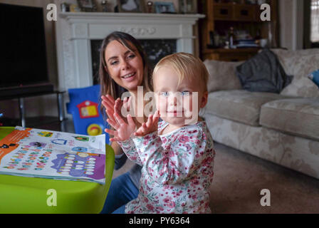 Junge zwei Jahre alten Baby Kleinkind Mädchen mit ihrer Mutter zu Hause spielen Stockfoto