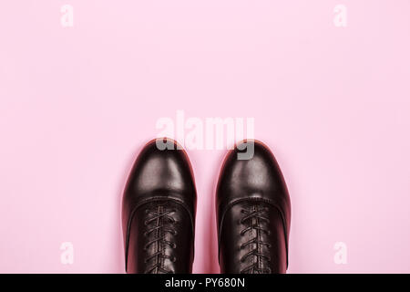 Glänzend ordentlich Paar schwarze Schuhe auf rosa Hintergrund. Kann als Fashion Concept mit Kopie Platz für die Signatur verwendet werden. Stockfoto