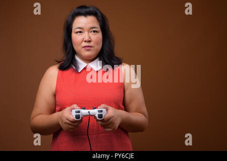 Schöne Übergewicht asiatische Frau spielen Videospiele mit Game Controller Stockfoto