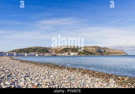 Ein Blick auf die Llandudno geschwungene Küstenlinie von White fronted Hotels gesäumt. Die Great Orme Landspitze ist in der Ferne und ein blauer Himmel ist oben. Stockfoto