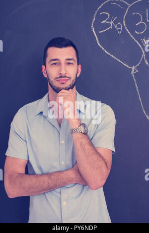 Portrait eines glücklichen jungen stilvollen Mann vor der schwarzen Tafel Stockfoto