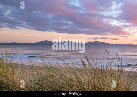 Sonnenuntergang über der Halbinsel Llŷn von den Sanddünen auf Southwold (llanddwyn) Strand, Anglesey, Nordwales Stockfoto