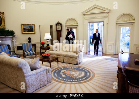 Präsident Barack Obama geht in das Oval Office im Weißen Haus Mittwochmorgen, 21. Januar 2009, für seinen ersten Tag im Amt. Seinen persönlichen Adjutanten Reggie Love steht in der Nähe.   Offiziellen White House Foto von Pete Souza Stockfoto