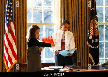 Präsident Barack Obama sieht tägliche Korrespondenz im Oval Office mit seiner persönlichen Sekretärin Katie Johnson 30.01.09. Offiziellen White House Photo by Pete Souza Stockfoto