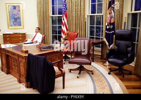 Präsident Barack Obama versucht aus verschiedenen Stühlen im Oval Office 30.01.09. Offiziellen White House Photo by Pete Souza Stockfoto