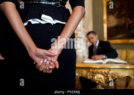 First Lady Michelle Obama wartet, während Präsident Barack Obama, Hintergrund, das Gästebuch bei ihrer Ankunft auf die Prager Burg, 5. April 2009, in der Tschechischen Republik unterzeichnet. Weiße Haus Foto/Pete Souza Stockfoto