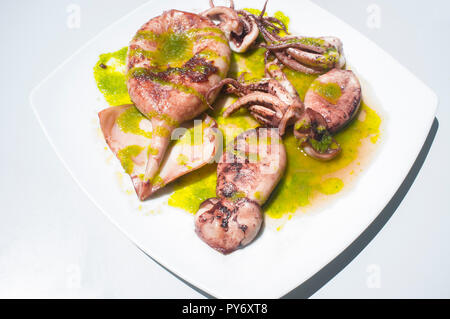 Bratpfanne Tintenfisch gewürzt mit grüne Petersilie. Overhead shot Stockfoto
