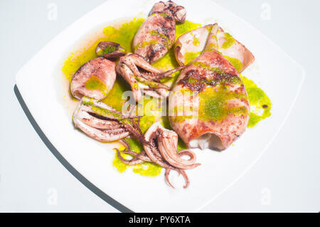 Bratpfanne Tintenfisch gewürzt mit grüne Petersilie. Overhead shot Stockfoto