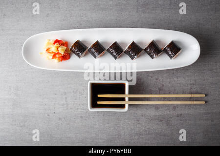 Maki Sushi serviert in langen Platte auf graue Tabelle Ansicht von oben Stockfoto