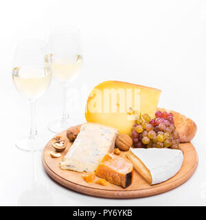 Käsebrett mit Trauben und Wein auf weißem Hintergrund. Vielzahl von weichen und harten Käse Stockfoto