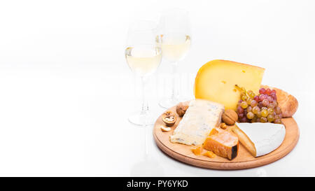 Käsebrett mit Trauben und Wein auf weißem Hintergrund. Vielzahl von weichen und harten Käse Stockfoto