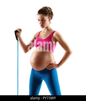 Sportliche schwangere Frau Training mit Expander auf weißem Hintergrund. Konzept des gesunden Lebens Stockfoto
