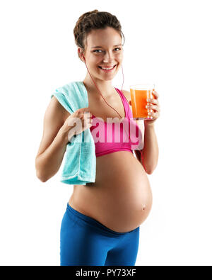 Ruhezeiten. Schwangere Frau in Sportbekleidung, Handtuch und ein Glas Orangensaft auf weißem Hintergrund. Konzept des gesunden Lebens Stockfoto