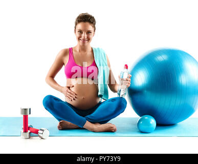 Ruhezeiten. Lächelnd schwangere Frau sitzend mit fitball auf weißem Hintergrund. Konzept des gesunden Lebens Stockfoto