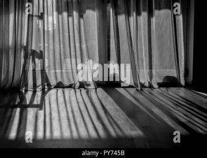 Vorhang Schatten auf den Holzboden in einer starken Nachmittag leuchtet Stockfoto