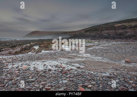 Landschaftsfotografie. Misty Morning blaue Stunde an der malerischen Felsstrand vor Sonnenaufgang in der Nähe von Tenby, Pembrokeshire, South Wales, UK. langen Belichtungszeit. Natur UK. M Stockfoto