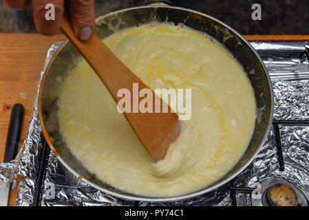 Zubereitung der traditionellen geschmolzenem Käse in einem Topf auf die Schweiz Stockfoto