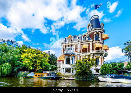 Typischen Kanal Szene mit historischen aristokratischen Häuser in Amsterdam unter blauem Himmel in den Niederlanden Stockfoto