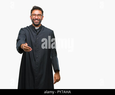 Nach spanischer katholischer Priester Mann über isolierte Hintergrund lächelt freundlich mit Handshake als Ansage und einladend. Erfolgreiches Business. Stockfoto