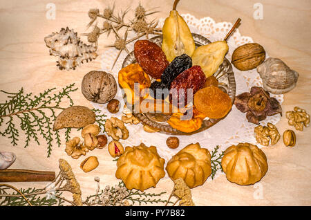 Crystal Rosette mit getrockneten frui, Muttern, Pistazie, Haselnuss, mit Eclairs, Zimt durch getrocknete Pflanzen und Muscheln auf einem stellte geformte Serviette umgeben Stockfoto