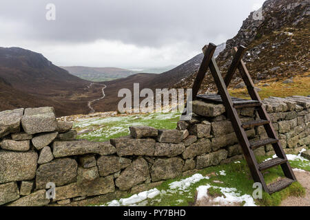 Holz- Stil über die Mourne Wall bei Hare's Gap mit Blick nach unten Trassey Track. Mourne Mountains, N. Irland. Stockfoto