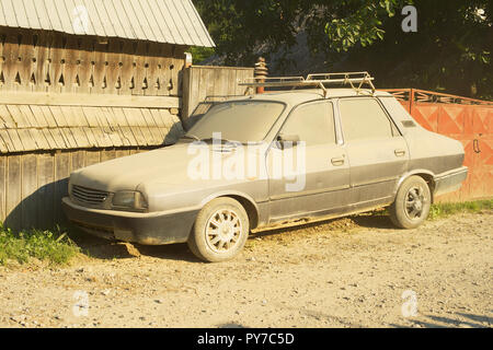 Auto durch Staub auf aa Dorfstraße abgedeckt. Rumänien Stockfoto