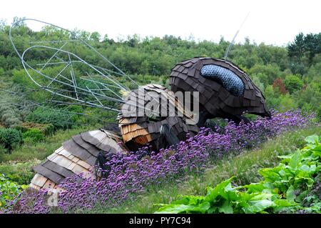 "Bombus die riesigen Biene' Skulptur von Robert Bradford Skulptur im Blumenbeet im Eden Project, Cornwall, UK. Stockfoto