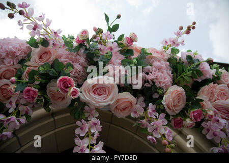 Girlande von künstlichen Rosen über Kirche Eingang Stockfoto
