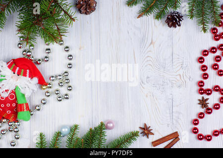 Das neue Jahr Rahmen mit Santa Claus's Toy, glänzenden Perlen und mit Tannenzweigen geschmückt. Neues Jahr Konzept. Gruß Weihnachtskarte. Flach. Stockfoto