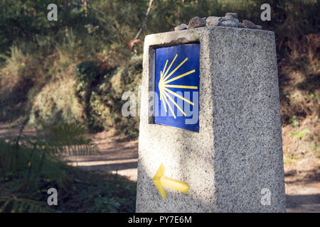 Camino de Santiago Meilenstein mit unscharfen Weg. Jakobsweg Zeichen Stockfoto