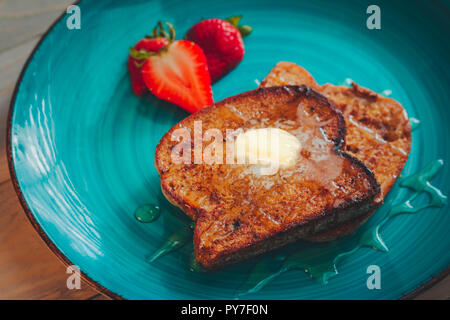 Hausgemachte französische Toast mit glutenfreien Brot, Erdbeeren und Ahornsirup Stockfoto