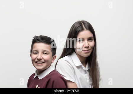 Großbritannien, England, Porträt von 10 Jahre alten Jungen und seiner Schwester im Teenageralter, sowohl in der Schule als unoforms. Studio Einstellungen Stockfoto